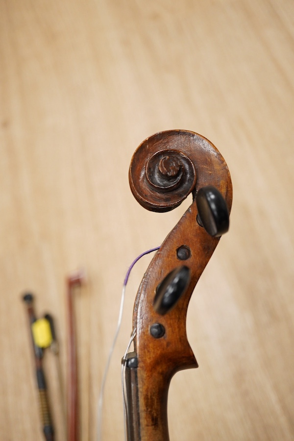 A late 19th century German violin, body 35cm long, and two bows. Condition - poor to fair.